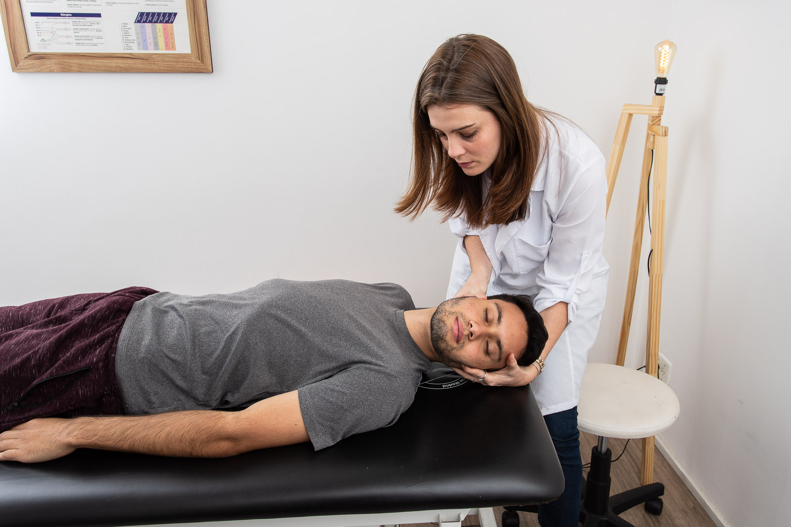 fisioterapeuta osteopata utilizando uma técnica de osteopatia para tratar a lesão em um jovem atleta