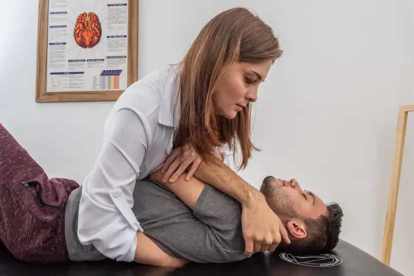 fisioterapeuta osteopata utilizando uma técnica de manipulação articular da coluna torácica no tratamento de osteopatia