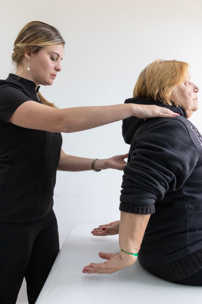 fisioterapeuta acompanha uma mulher em uma sessão de fisioterapia e pilates clínico